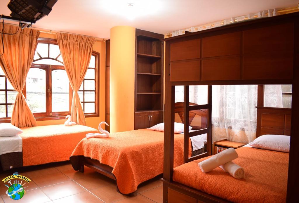 a bedroom with two bunk beds and a window at Hostal Viajero's in Baños