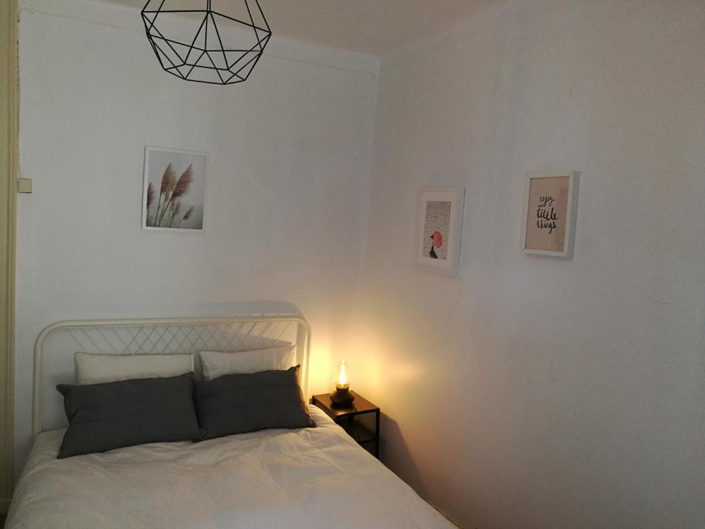 a bedroom with a bed with a lamp and pictures on the wall at Santa Marta Apartment in Lisbon