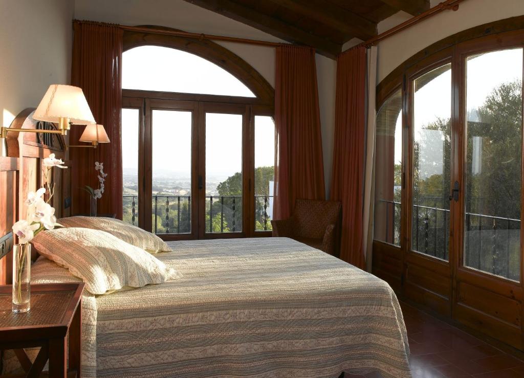 a bedroom with a bed and a large window at Mas Ses Vinyes - Adults Only in Begur