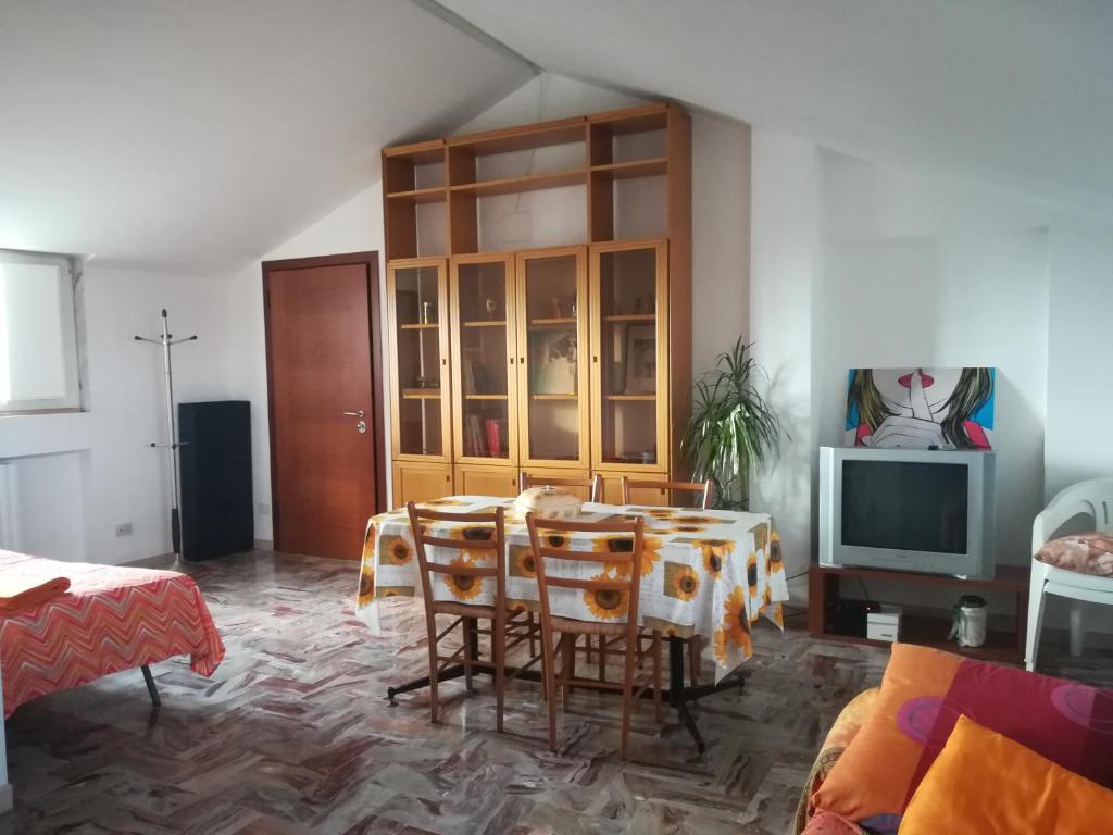 ein Wohnzimmer mit einem Tisch und Stühlen sowie einem TV in der Unterkunft Appartamento A Campobasso in Campobasso