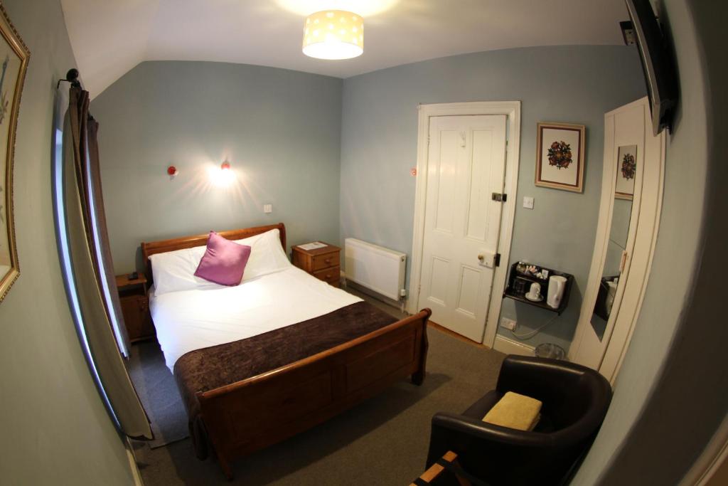 a small bedroom with a bed and a chair at Rolling Wave Guesthouse in Bundoran