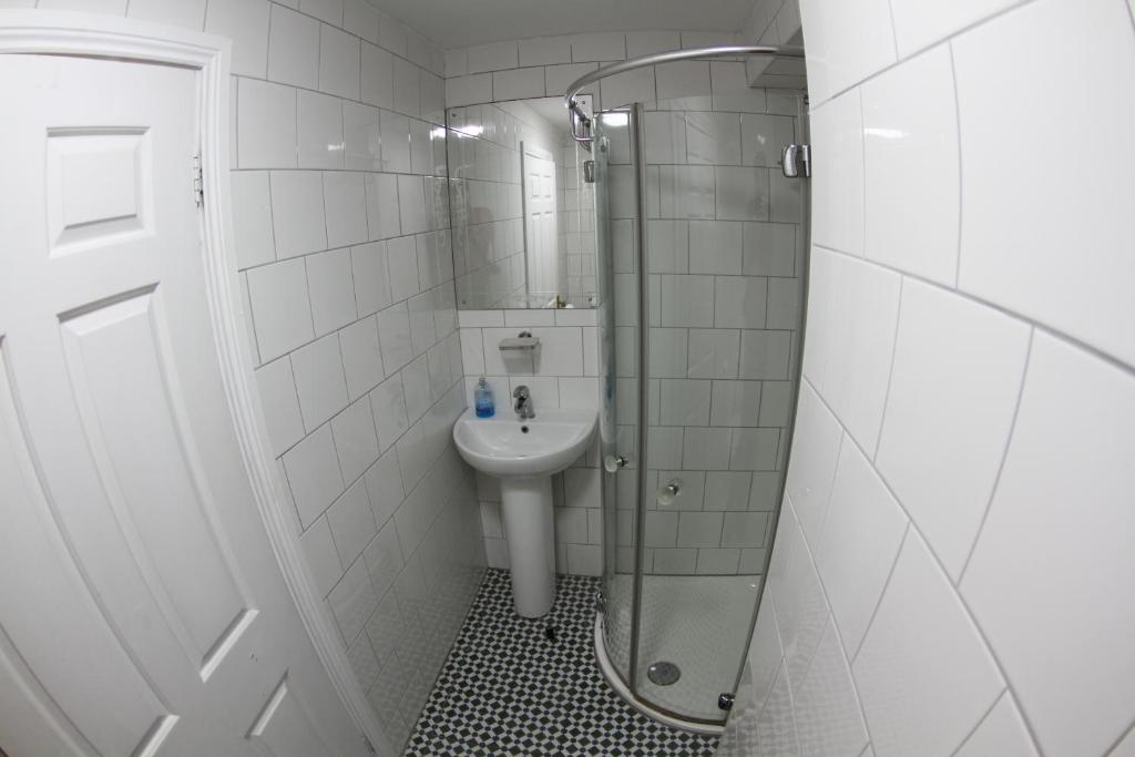a small bathroom with a sink and a shower at Rolling Wave Guesthouse in Bundoran