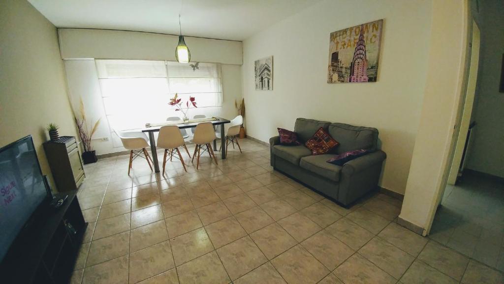 ein Wohnzimmer mit einem Sofa und einem Tisch in der Unterkunft San Martin 900 con estacionamiento in Cipolletti