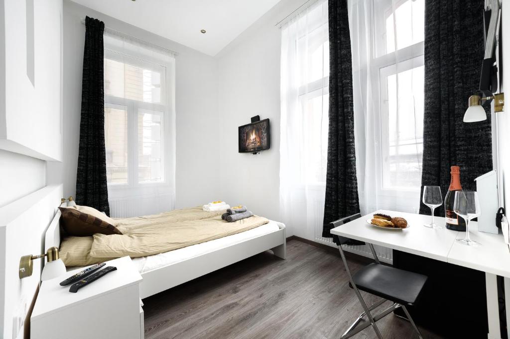 a white bedroom with a bed and a desk at Annabelle Downtown Apartments in Budapest