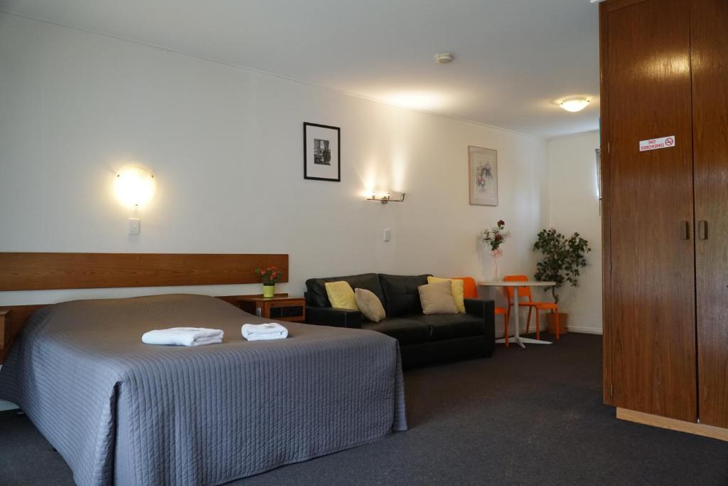 a hotel room with a bed and a couch at Melaleuca Lodge Beaconsfield in Beaconsfield