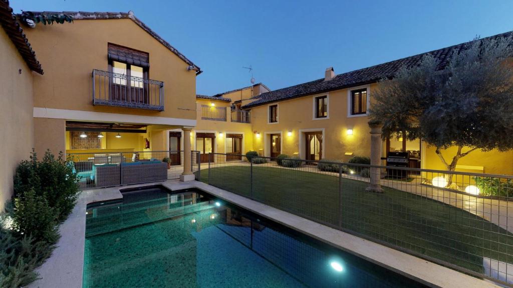 una casa con piscina frente a una casa en Villa Cornelius Lujo Rural 5 Estrellas Verdes, en Las Herencias