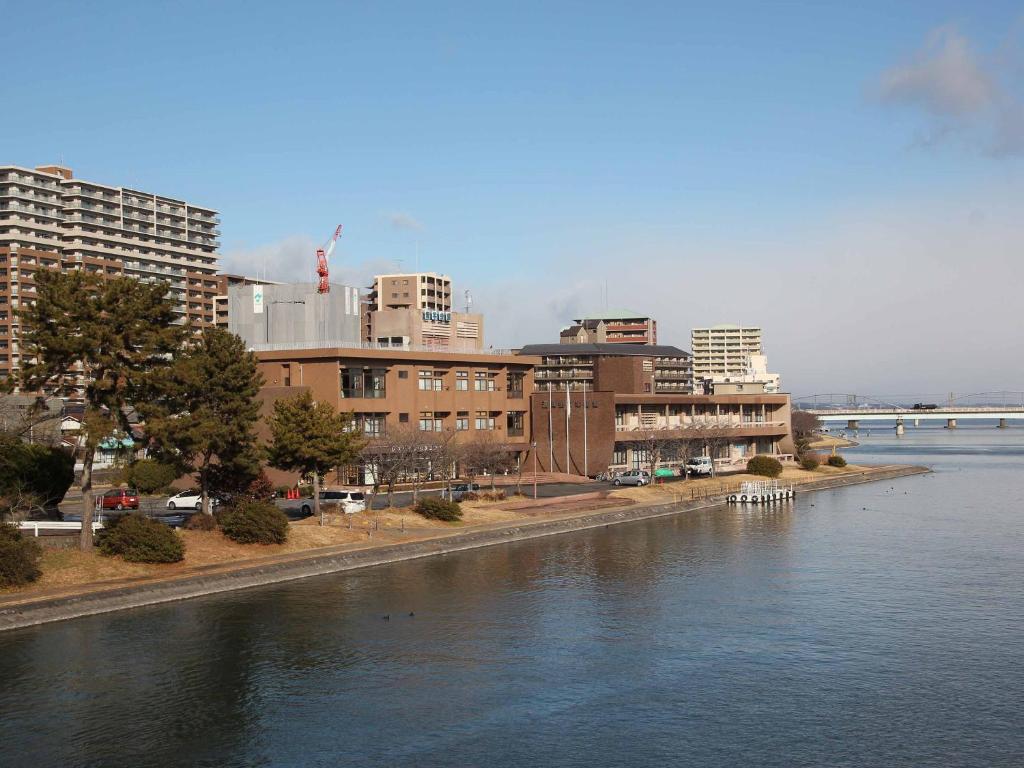a view of a river with buildings and a city at Hotel ab Shiga in Otsu