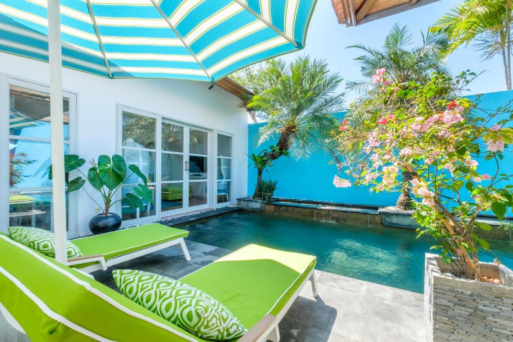 una piscina cubierta con sillas y sombrilla en THE CABANA, en Sanur
