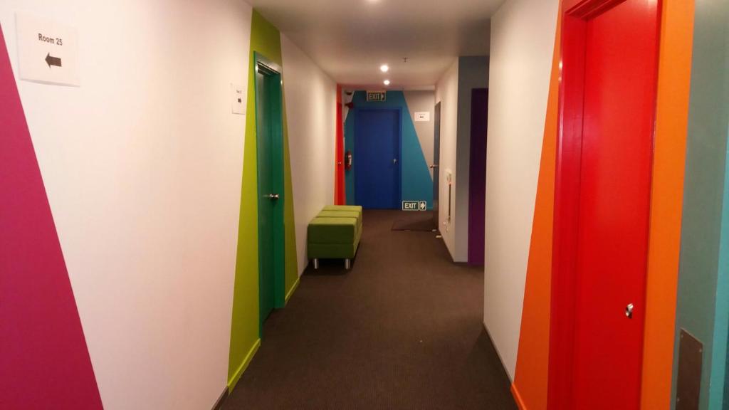 a hallway with colored doors and chairs in a room at YHA Nelson in Nelson