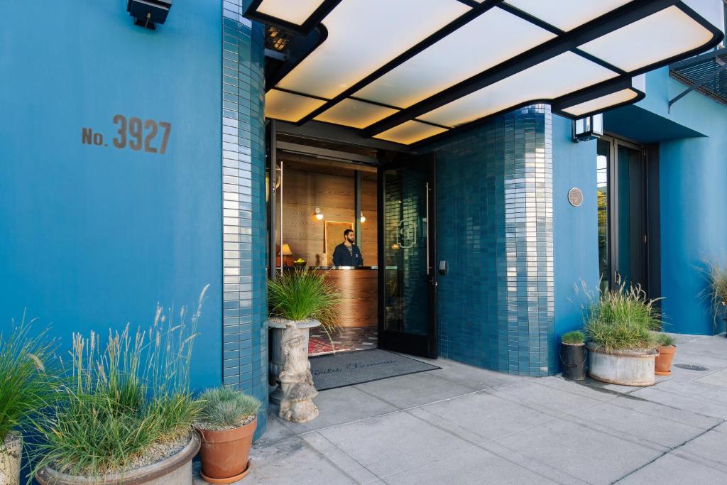 a blue building with a person standing in the doorway at Palihotel Culver City in Los Angeles