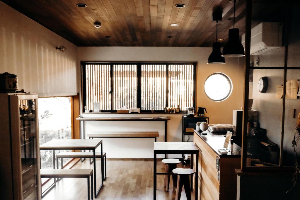 a kitchen with two tables and chairs and a window at Guesthouse Nedoko in Nakatsugawa