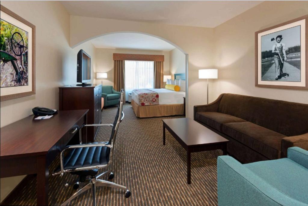 a hotel room with a couch and a bed at Best Western Plus Dayton in Dayton