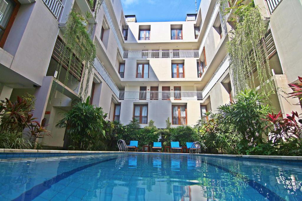a swimming pool in front of a building at The Legian Sunset Residence in Seminyak