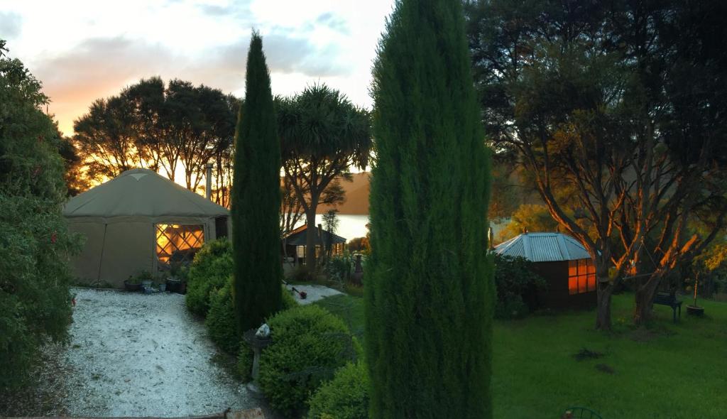 Blick auf einen Garten mit Bäumen und einem Pavillon in der Unterkunft Ngahere Hou Glamping in Kenepuru Head