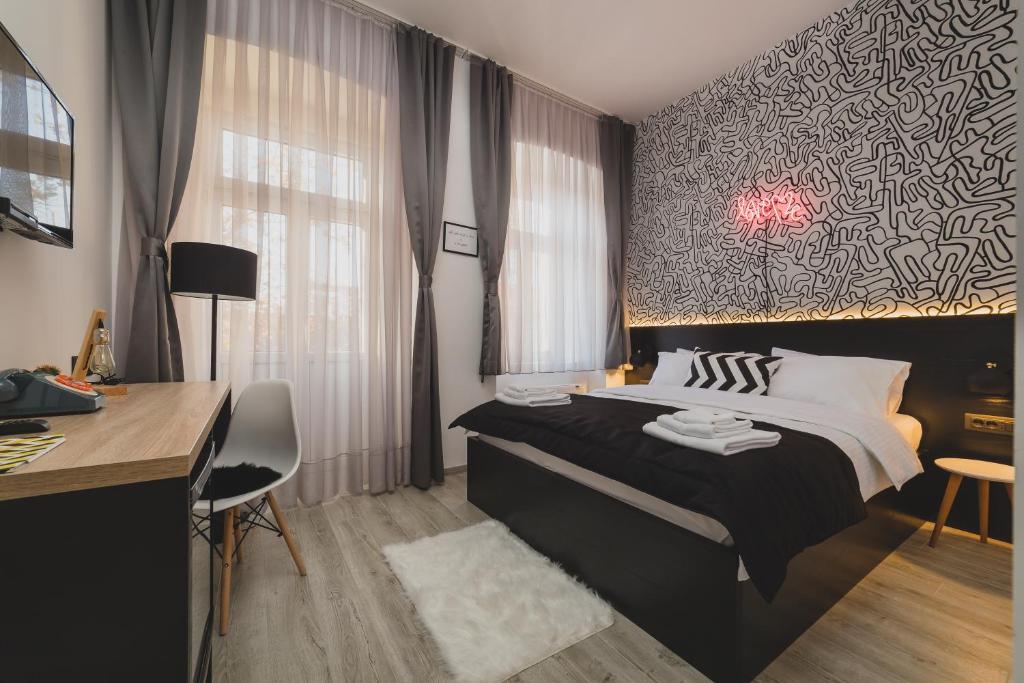 1 dormitorio con 1 cama grande, escritorio y en Hotel Marienplatz Podgorica, en Podgorica
