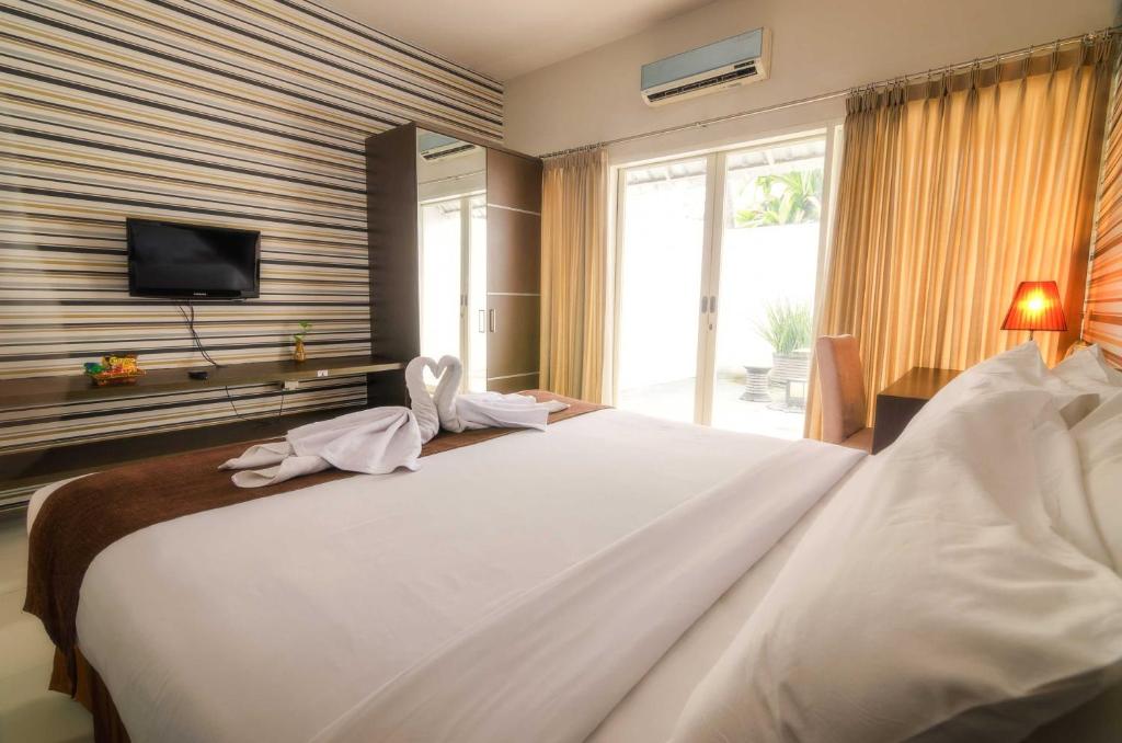 Postel nebo postele na pokoji v ubytování The Square Surabaya Hotel