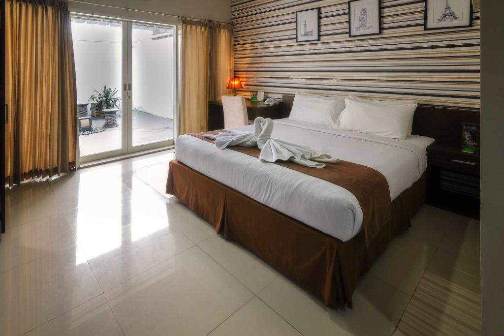 Postel nebo postele na pokoji v ubytování The Square Surabaya Hotel