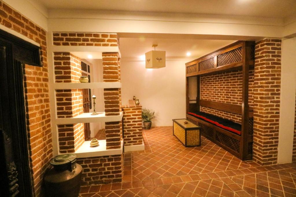a room with a brick wall and a fireplace at Chibha Classic Inn in Pātan