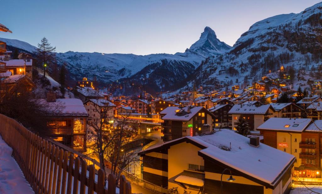 a town in the mountains at night with snow at Hotel Welschen in Zermatt