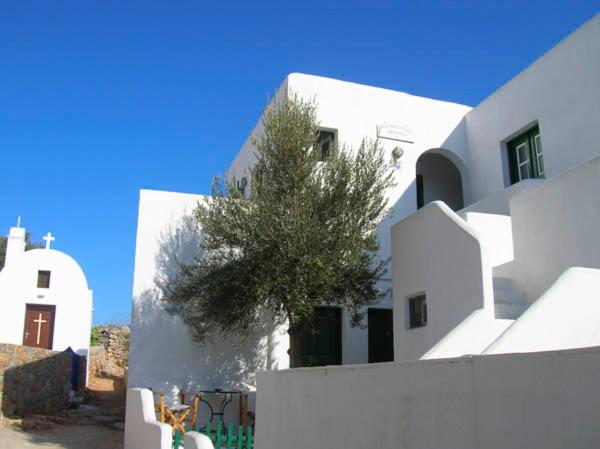 a white building with a tree in front of it at Irene Rooms in Chora Folegandros