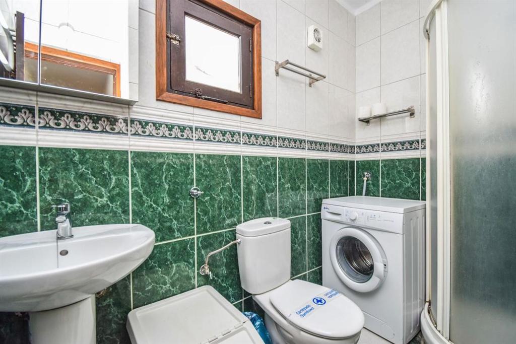 W łazience znajduje się toaleta, umywalka i pralka. w obiekcie El Capistrano Playa 301 w mieście Nerja