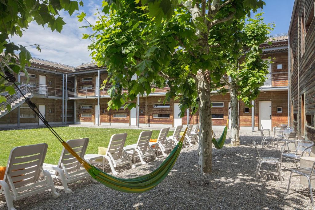 a patio area with chairs, tables and umbrellas at Lausanne Youth Hostel Jeunotel in Lausanne
