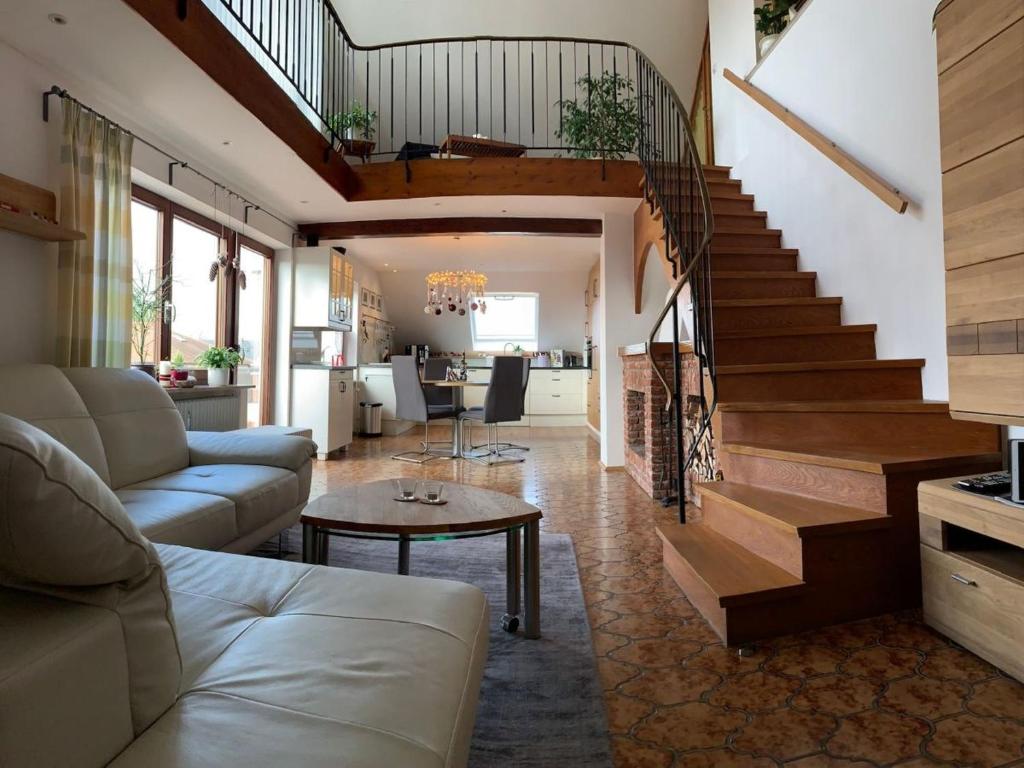 ein Wohnzimmer mit einem Sofa und einer Treppe in der Unterkunft Maisonette am See in Nonnenhorn
