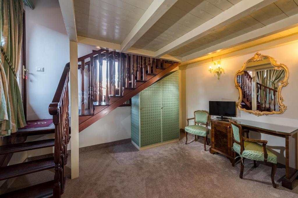 a room with a staircase and a desk and a mirror at Hotel Giorgione in Venice