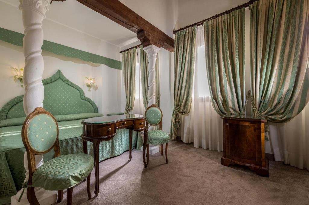 a bedroom with a bed and a desk and chairs at Hotel Giorgione in Venice