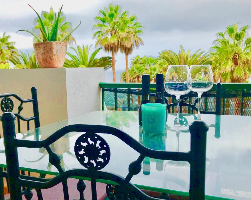 a glass table with wine glasses on a balcony at Esmeralda in Callao Salvaje