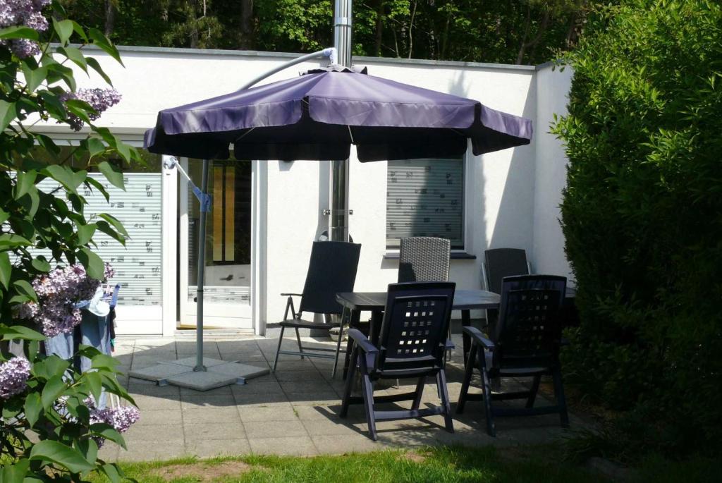 a table and chairs under an umbrella on a patio at Ostsee Bungalow Stolteraa _ Objekt in Diedrichshagen