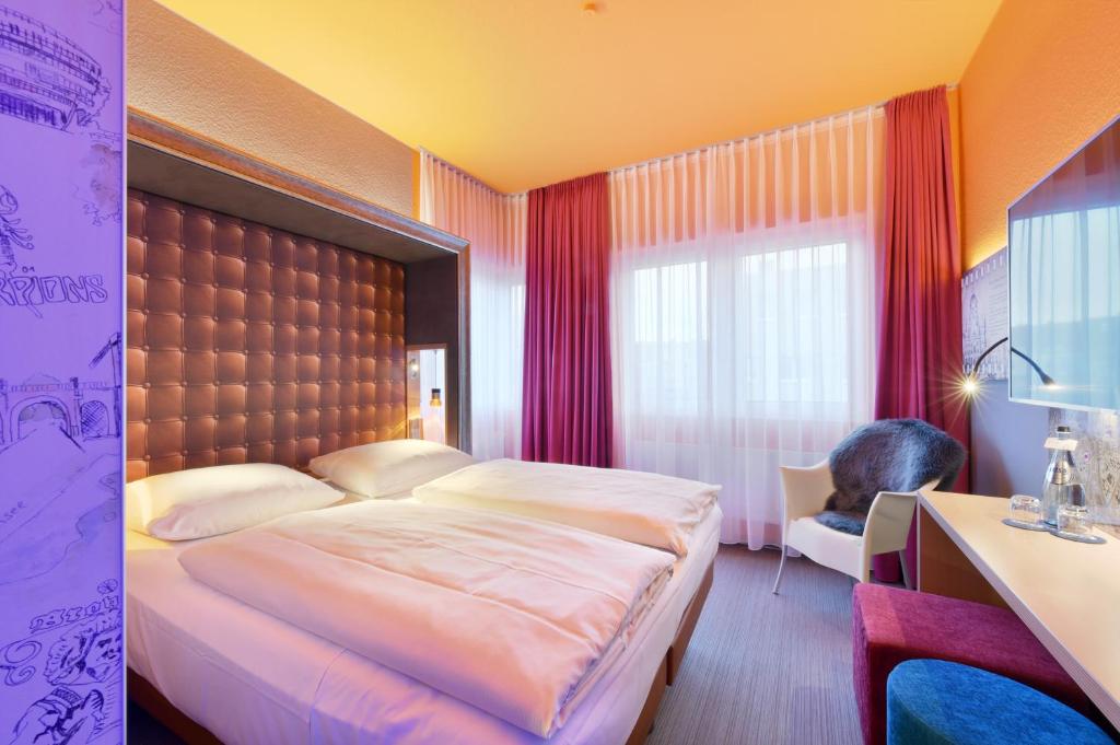 een slaapkamer met een groot bed en een raam bij Designhotel + CongressCentrum Wienecke XI. in Hannover