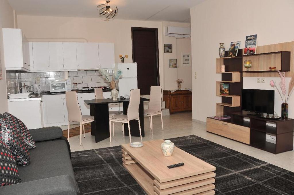 ein Wohnzimmer und eine Küche mit einem Sofa und einem Tisch in der Unterkunft Giota's House in Kalambaka