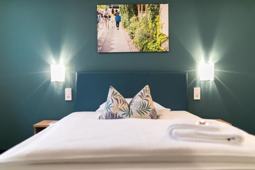 a bed with two pillows in a room with two lights at martas Hotel Allegra Berlin in Berlin