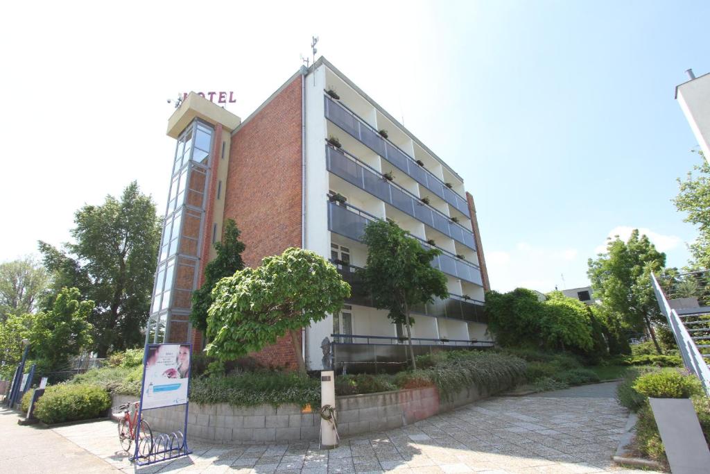 a red brick building with trees in front of it at Hotel Móló in Siófok