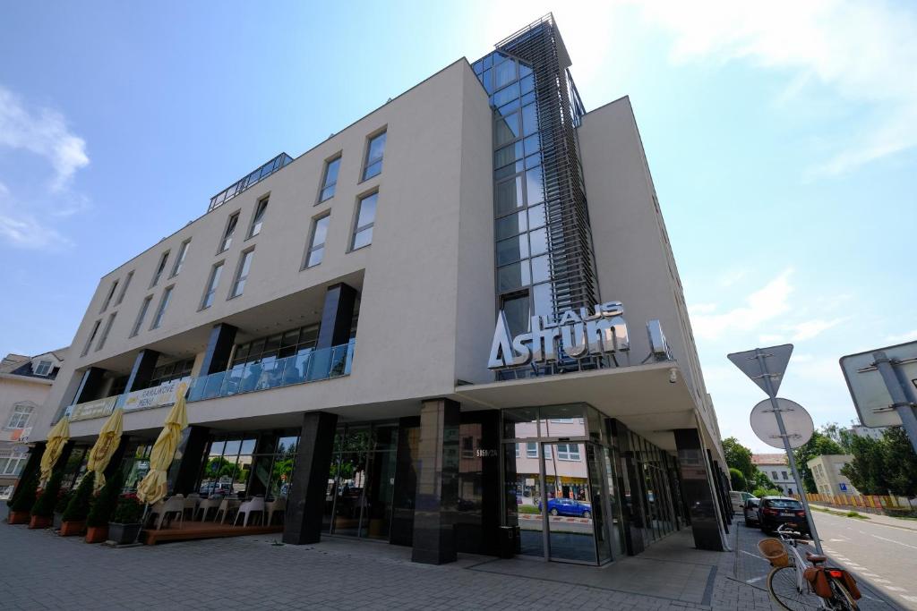 a large apartment building on a city street at Business Hotel Astrum Laus in Levice