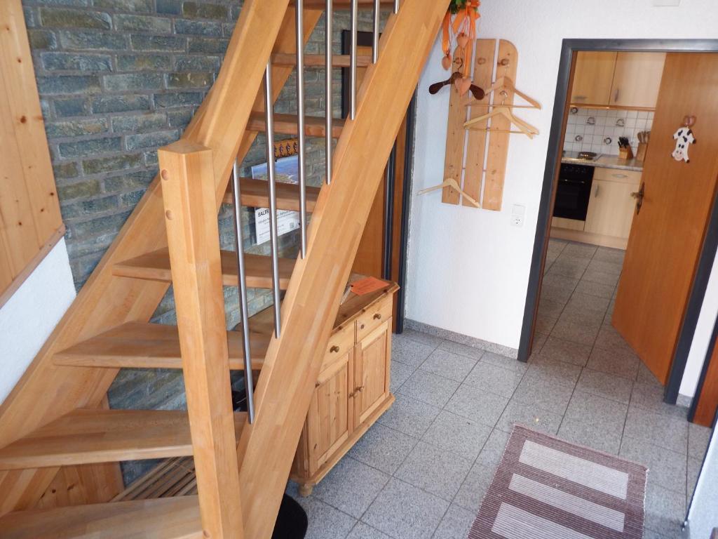 Una escalera de madera en una habitación con una habitación en Strandmensch Dornumersiel, en Dornum