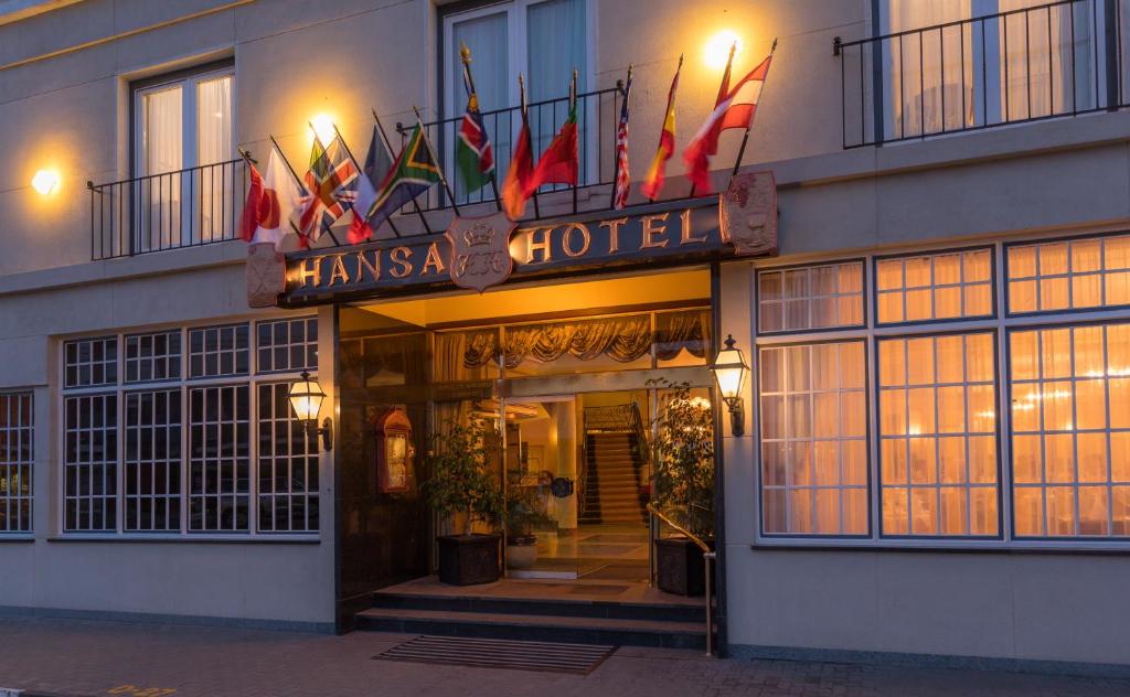 un hotel con banderas en la parte delantera en Hansa Hotel Swakopmund en Swakopmund