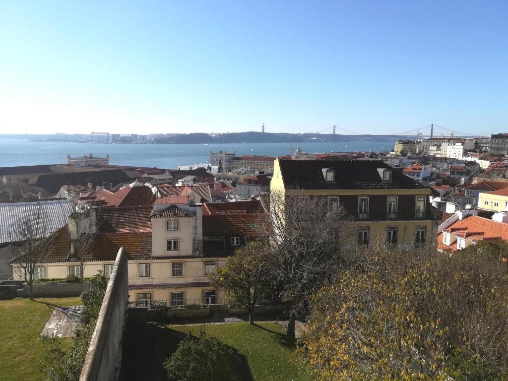 uma cidade com casas e a água ao fundo em Casa Rio da Saudade em Lisboa