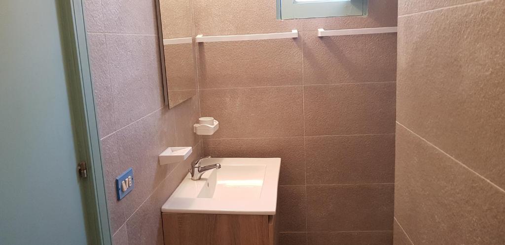 ein Bad mit einem Waschbecken und einem Spiegel in der Unterkunft VILLA RISORGIMENTO in centro sul corso principale in Scoglitti