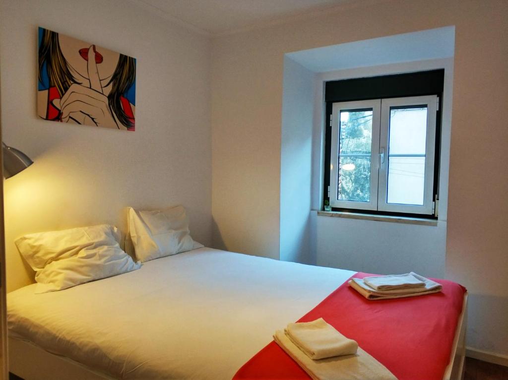 um quarto com uma cama branca e uma janela em Be 1 of Us Central Lisbon Bairro Alto Santa Catarina em Lisboa