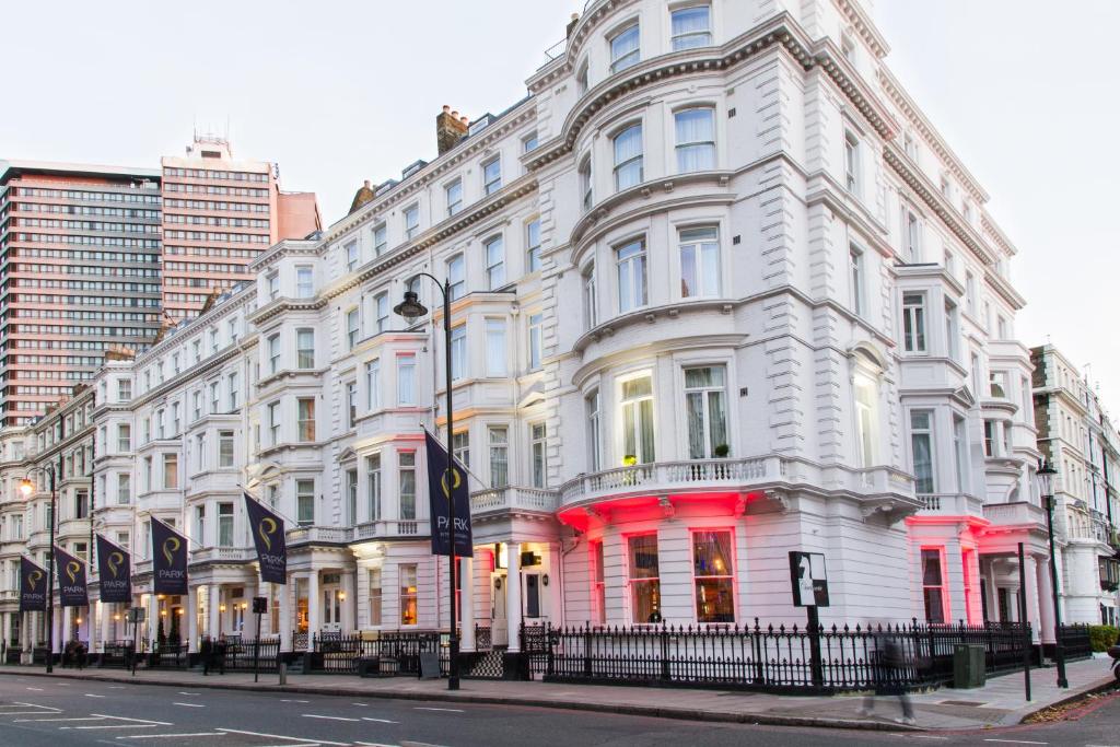 a white building with red lights on a street at Park International Hotel in London