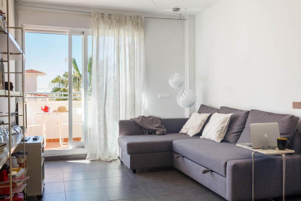 a living room with a couch and a laptop at Ático en el mar in Alcossebre