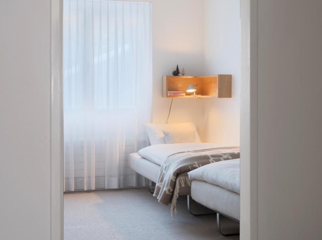 a room with two beds and a window at Haus-Ascot-Zermatt in Zermatt