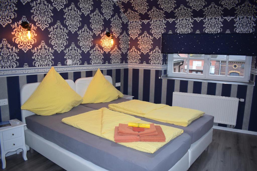 a bedroom with a bed with yellow and blue at Gast-und Weinhaus Zwiebelturm in Kerken