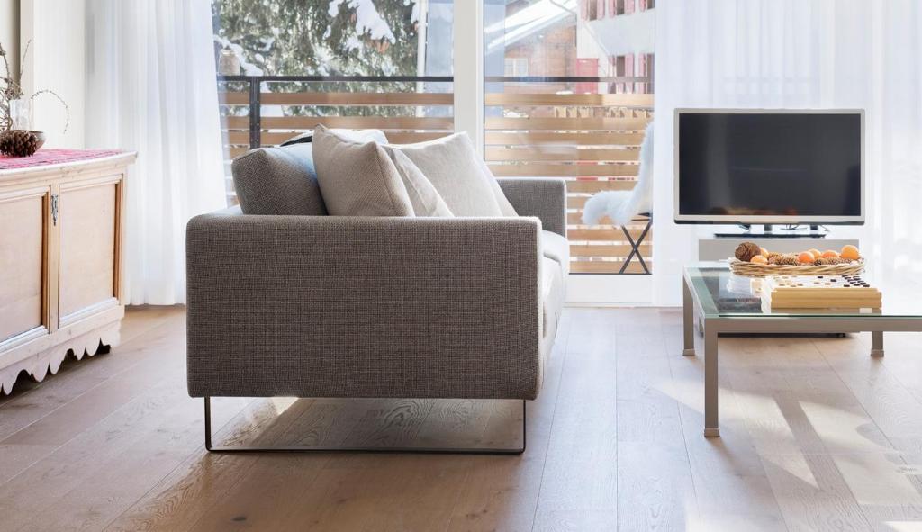 a living room with a couch and a tv at Haus-Ascot-Zermatt in Zermatt