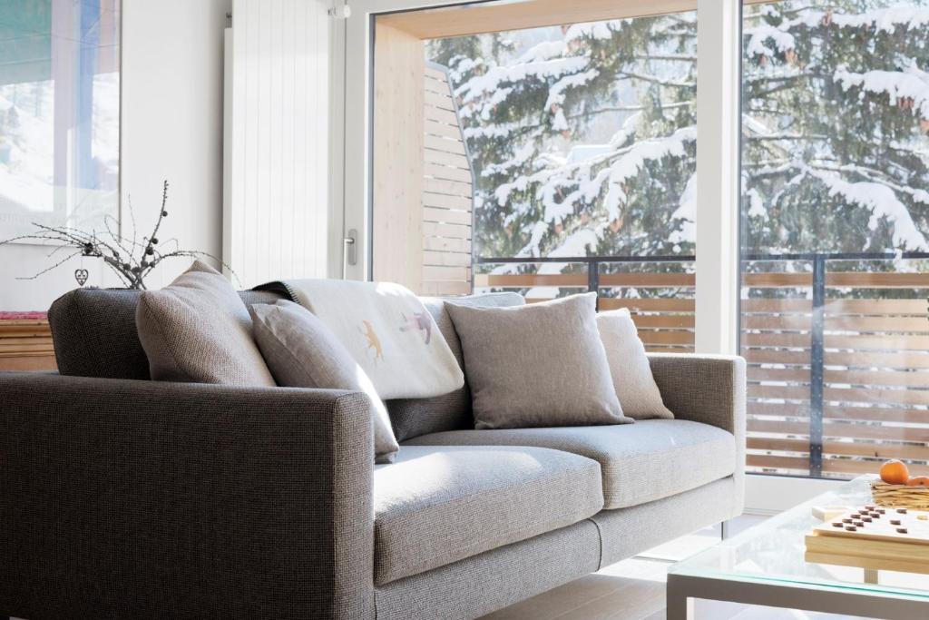 a living room with a couch and a window at Haus-Ascot-Zermatt in Zermatt