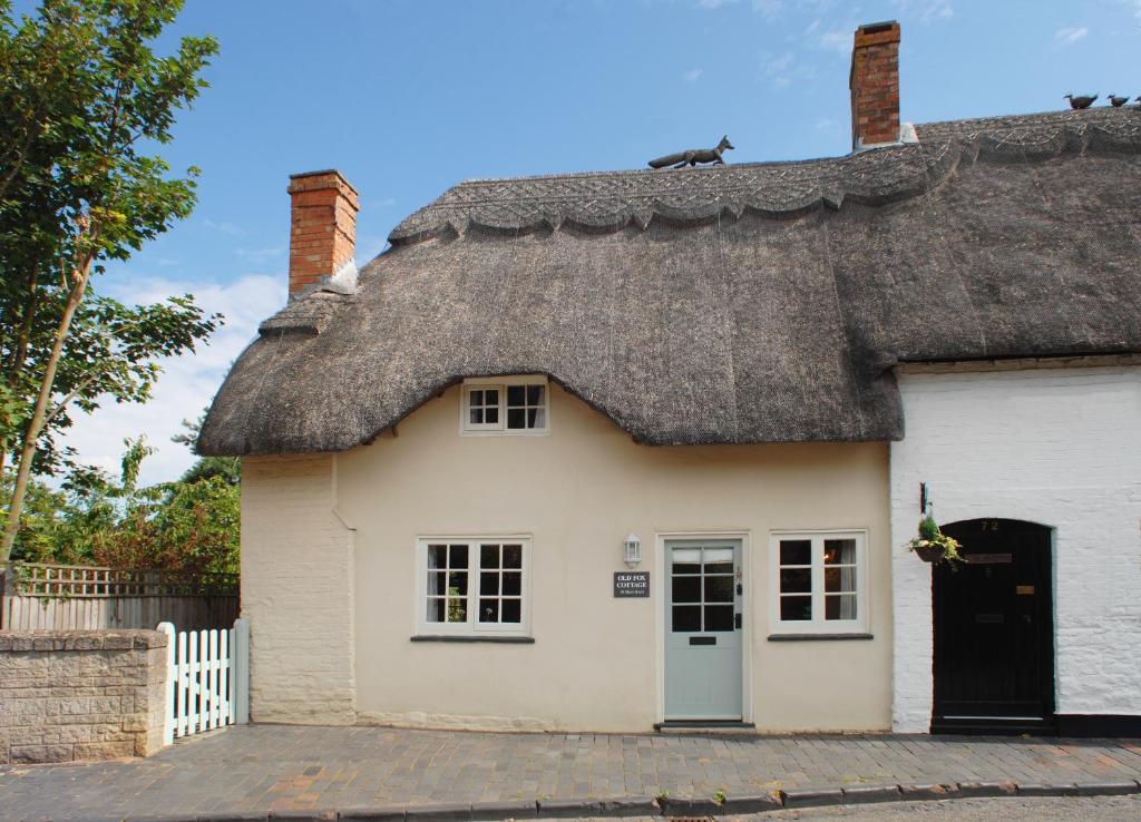 ein strohgedecktes Cottage mit einem Strohdach in der Unterkunft Old Fox Cottage in Evesham
