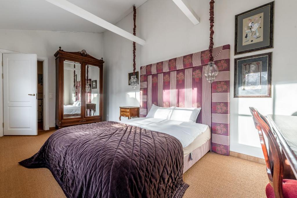- une chambre avec un lit et une couverture violette dans l'établissement Angel House Vilnius, 4A, à Vilnius