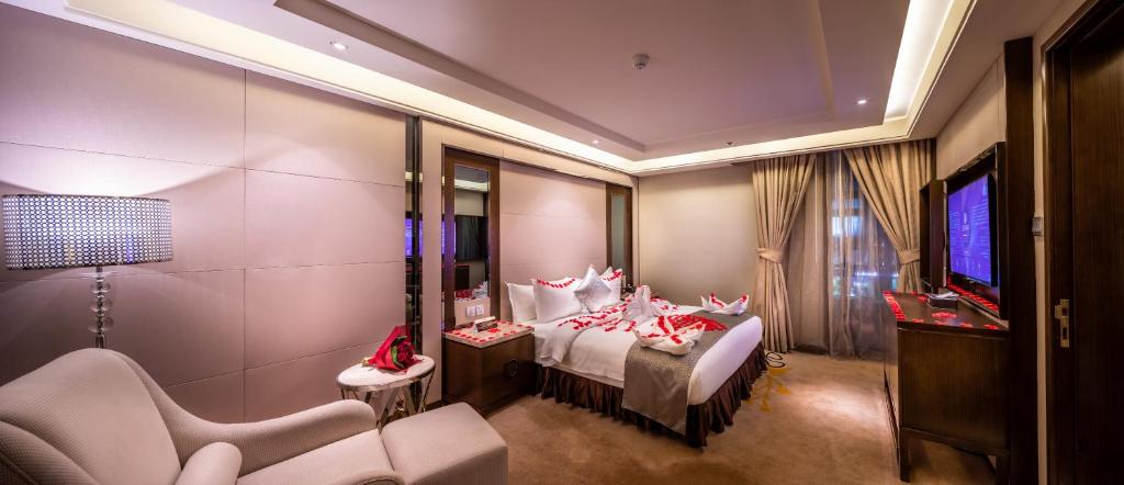 um quarto com uma cama, uma televisão e cadeiras em Braira Al Olaya em Riade